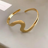 Pulsera clásica abierta con ola de oro